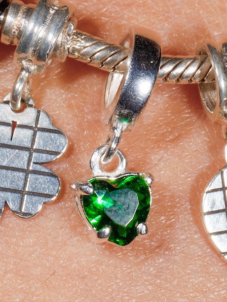 Berloque com zircônia verde em formato de coração, pendurado na pulseira