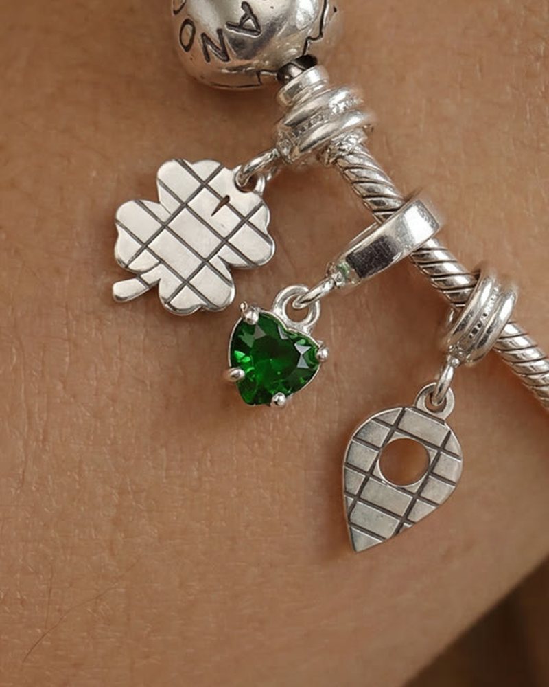 Berloque verde na pulseira, no pulso da Beta
